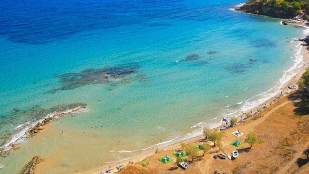 A beach with clear turquoise waters, a sandy shore, and a few umbrellas and boats. - Scenic Villa in Pigadakia With Private Pool (Zakynthos)
