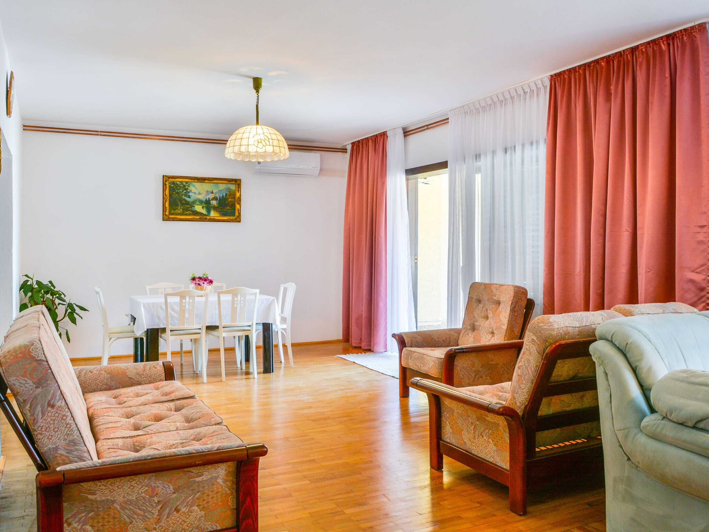 A living room with a dining area, wooden flooring, and a ceiling fan.