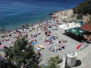 A crowded beach with people sunbathing and swimming, umbrellas, and outdoor seating areas. - Holiday Home in Senj With Pool Near Beach (Senj)