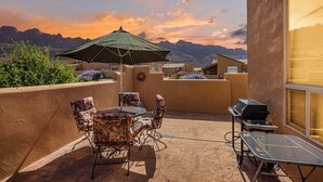 A patio with a table and chairs, a grill, and an umbrella. - Great Location Near Parks | Pet-Friendly | Pool + Hot Tub Access (Moab)