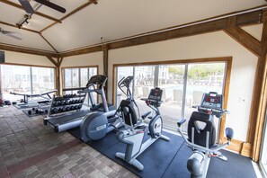 Een fitnessruimte met loopbanden, elliptische trainers en losse gewichten.