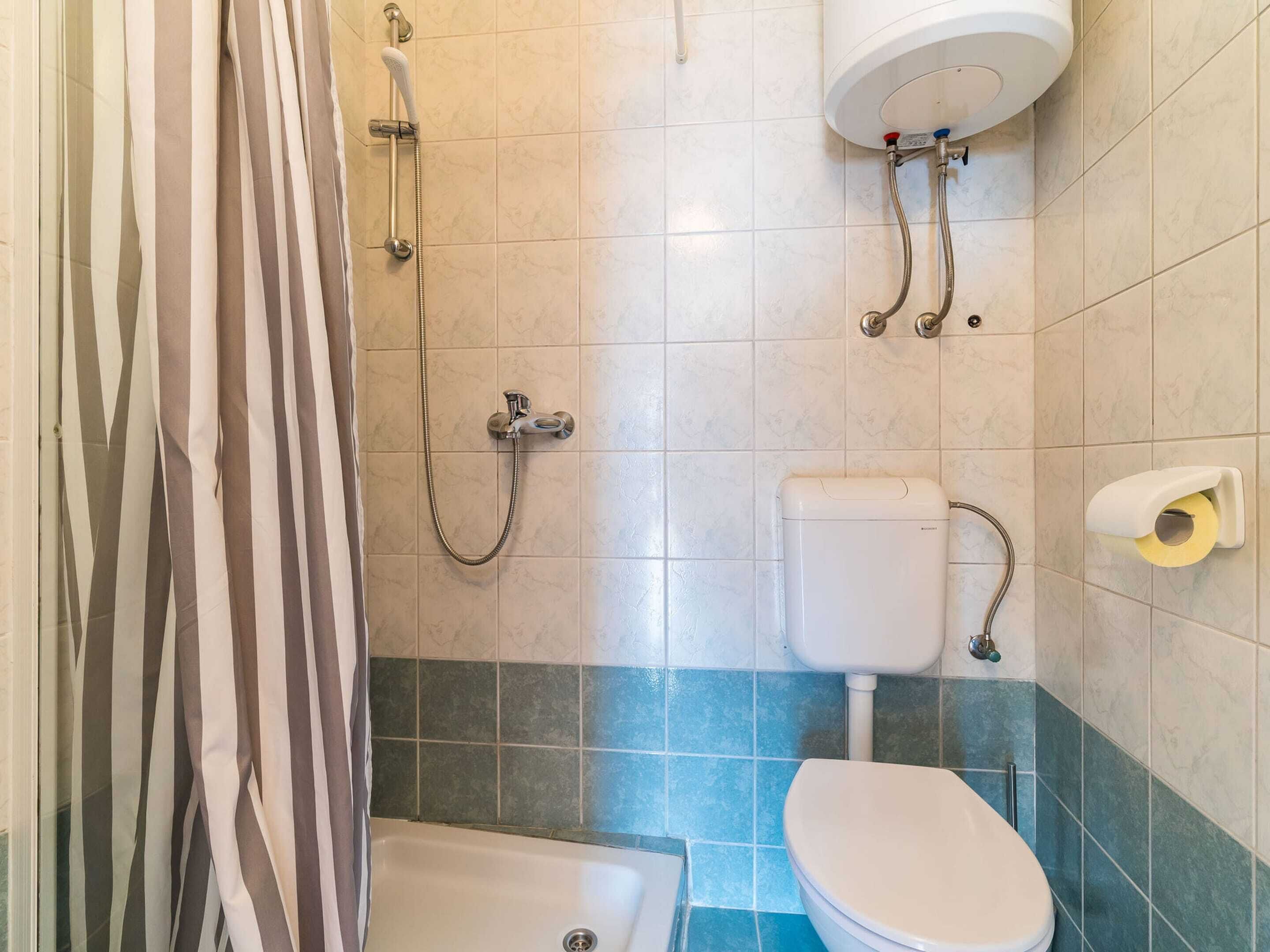 Un baño con ducha, inodoro y bañera.