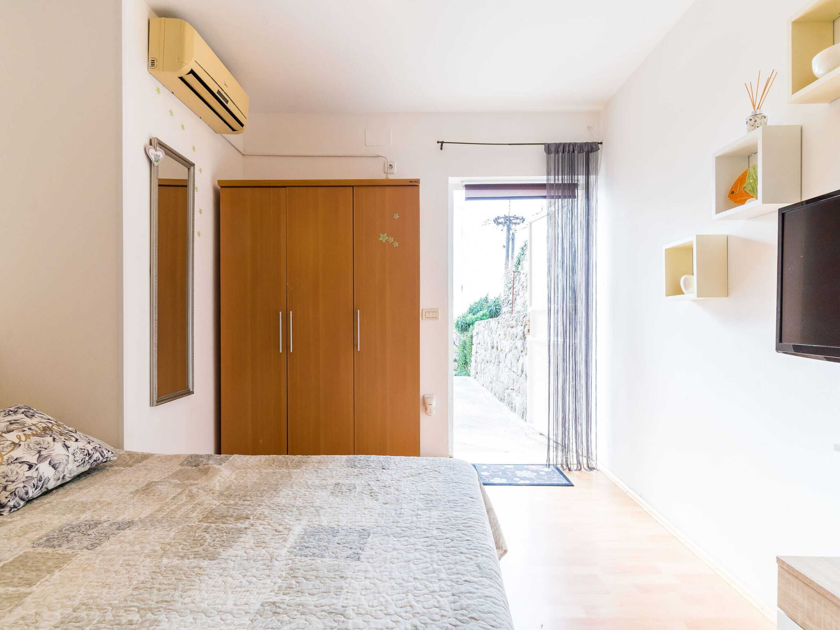 A bedroom with a bed, wardrobe, and a TV.
