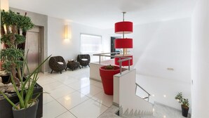 A modern interior with a staircase, seating area, and potted plants. - 1742 Silver Hotel - Le Triple (Matino)