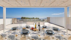 A dining table set for four with a view of the sea. - 1934 Villa Punta Ristola (Castrignano del Capo)