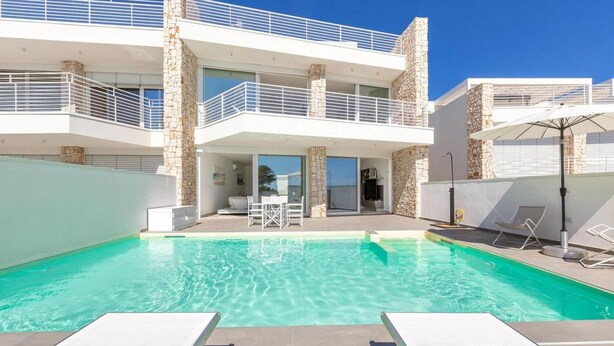 A modern two-story building with a swimming pool, outdoor seating, and a stone facade. - 1934 Villa Punta Ristola (Castrignano del Capo)