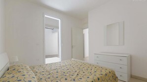 A bedroom with a bed, a dresser, a mirror, and a door leading to another room. - 2371 Villette Girovagando - Trilo Superior by Barbarhouse (Melendugno)