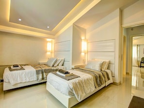 A modern hotel room with two beds, each with a headboard, bedside tables, and wall-mounted lamps. - Villa in Tragaki With Pool (Zakynthos)
