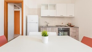Une cuisine moderne avec des meubles blancs, un four encastré et un évier.