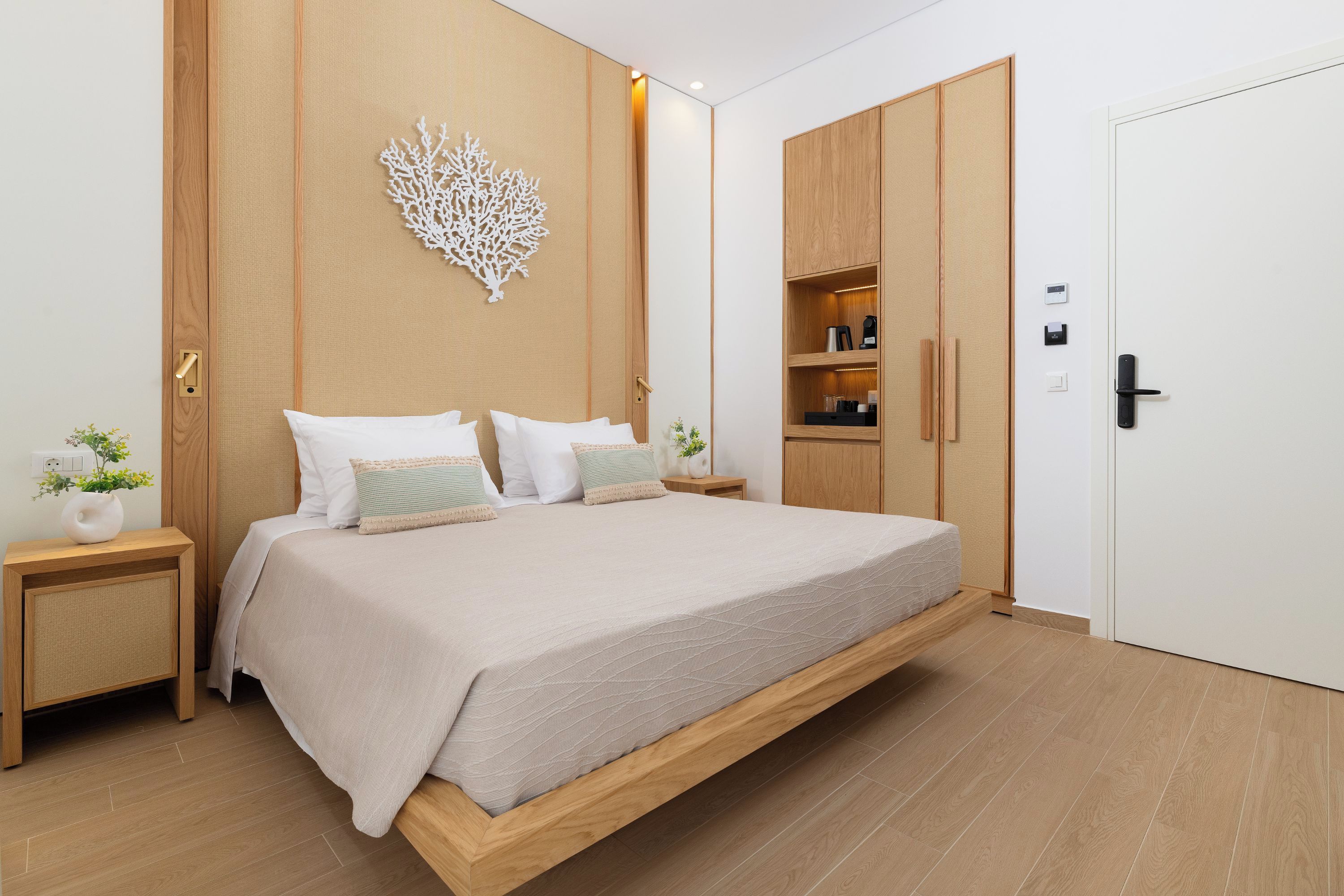 Un dormitorio moderno con cama, mesitas de noche, un armario y un adorno en la pared.