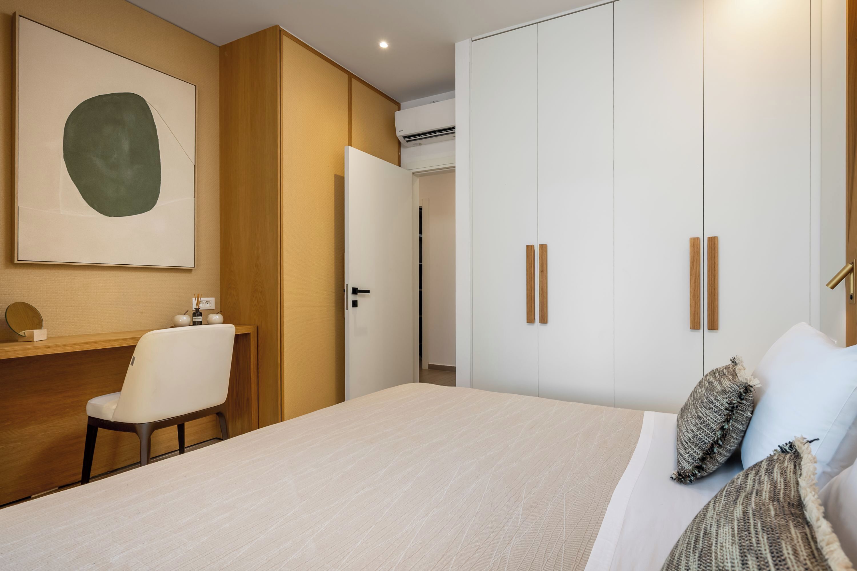 A hotel room with a bed, a desk, and a wardrobe.