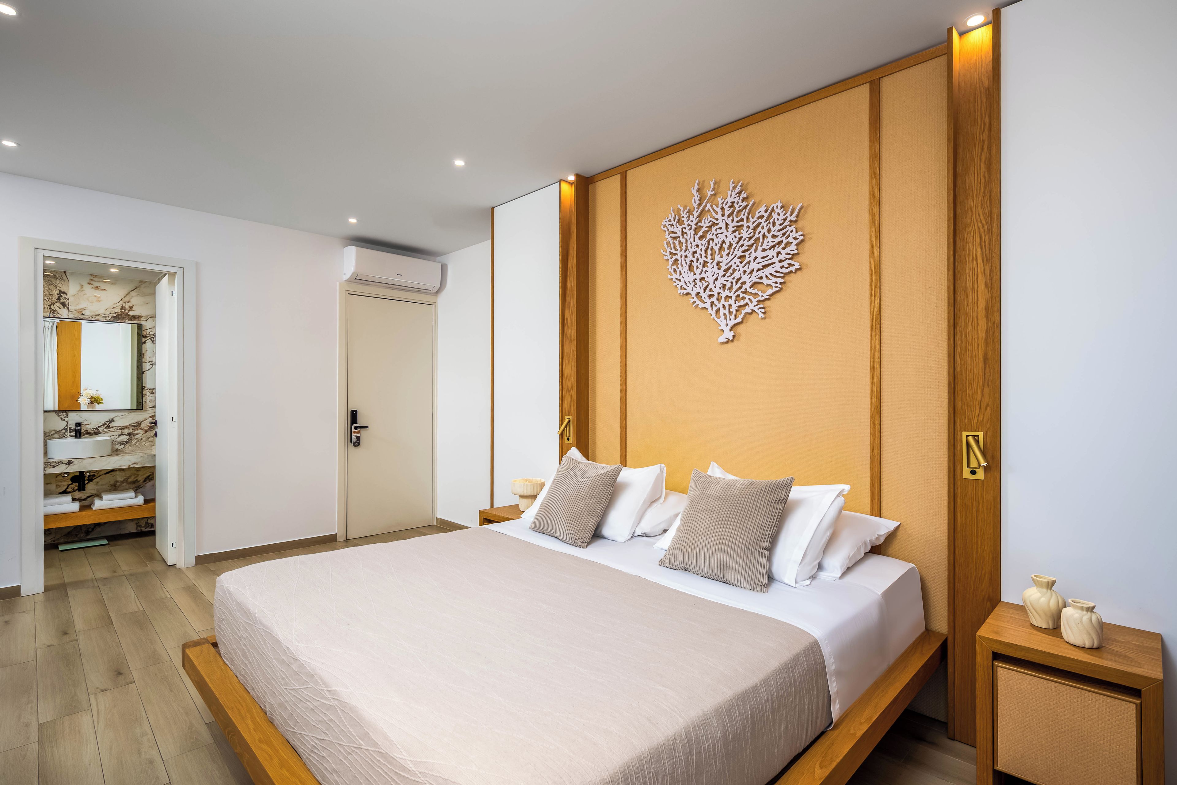 Une chambre à coucher moderne avec un grand lit, une tête de lit en bois et un élément décoratif mural.