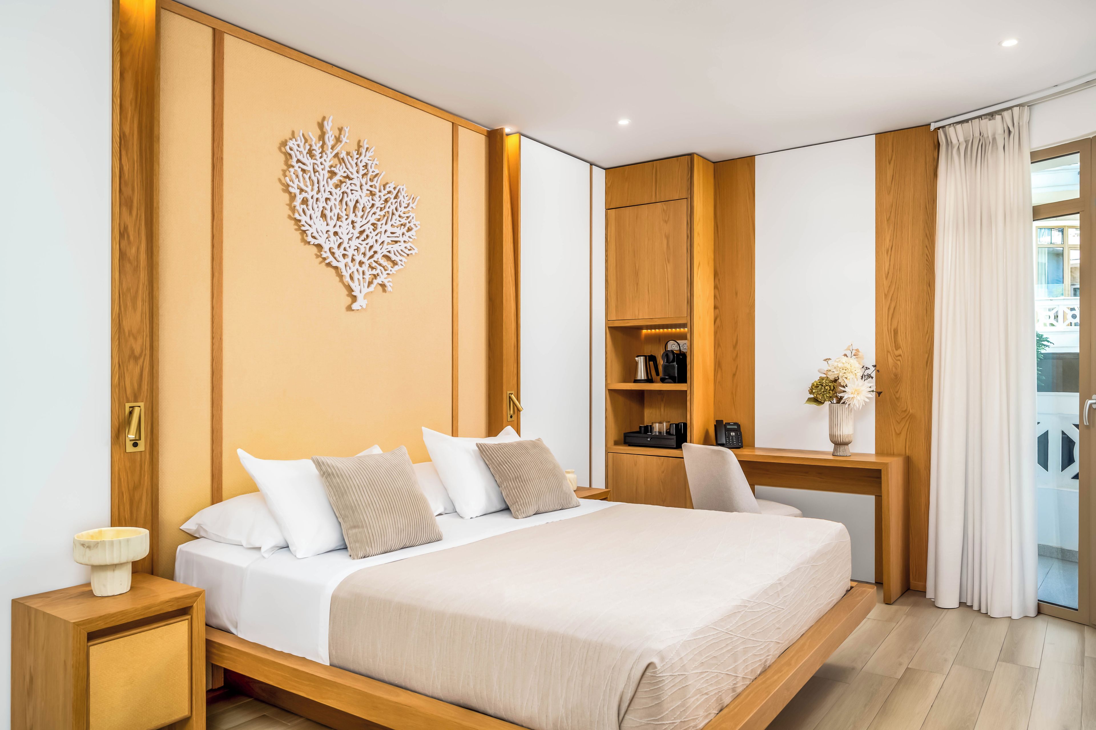 Une chambre d’hôtel moderne avec un grand lit, une tête de lit en bois et un élément décoratif mural.