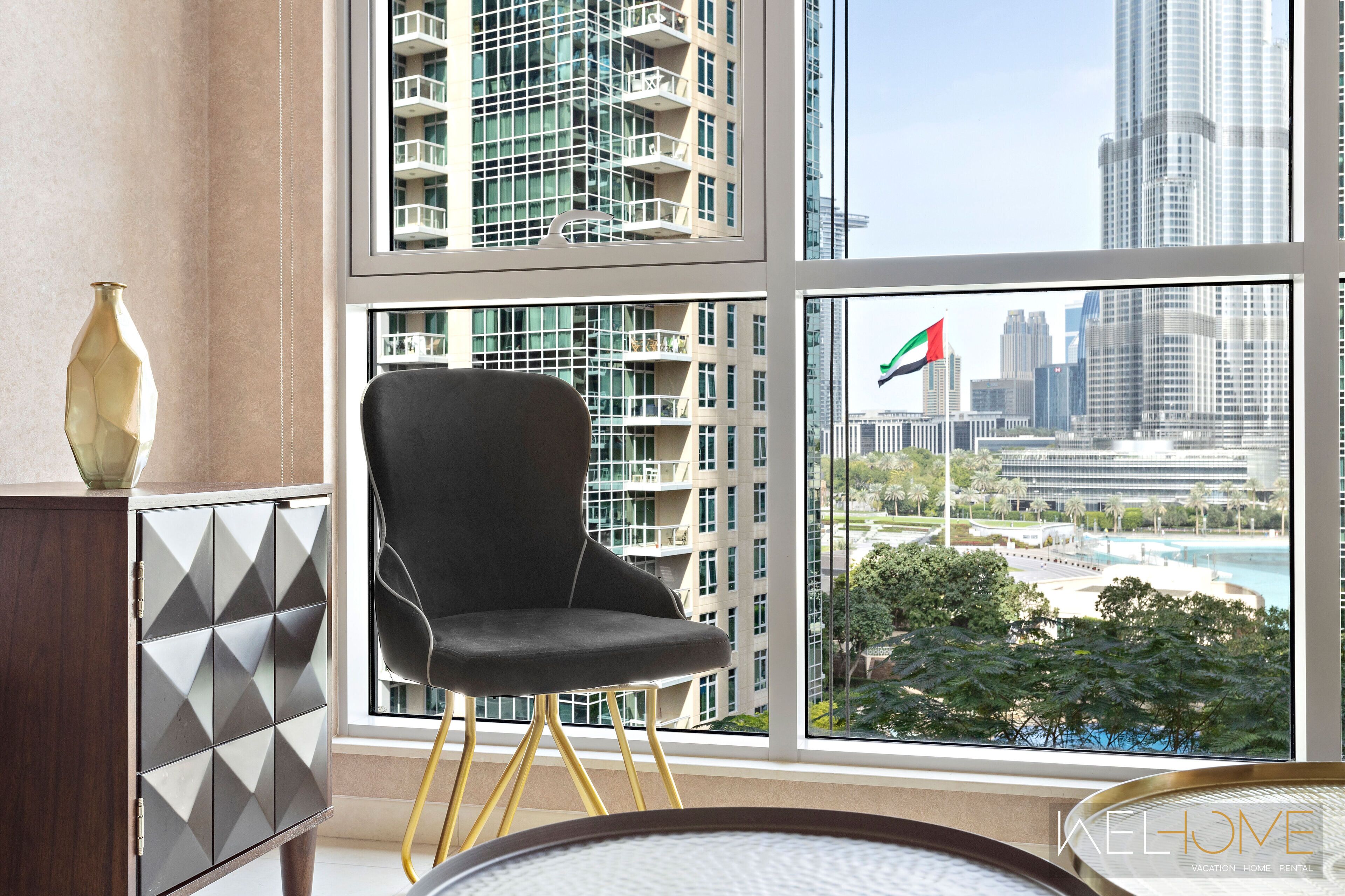 Une chambre moderne avec une grande fenêtre, une chaise noire et un meuble décoratif.