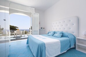 Ein Schlafzimmer mit einem großen Bett, einem Balkon mit Blick und einem weißen Farbschema.