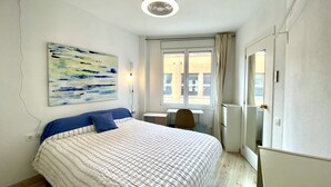Une chambre à coucher avec un lit, un bureau et une fenêtre.