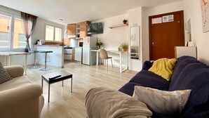 Un appartement moderne comprenant un salon, une cuisine et un coin repas.