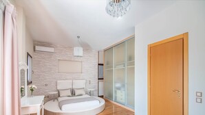 A modern bedroom with a round bed, a white desk, a chandelier, and a sliding glass door. - Inviting Villa in Anavissos With Communal Pool (Saronikos)