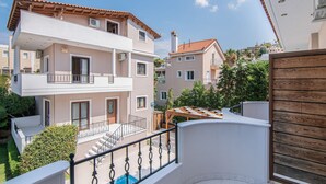 A multi-story residential building with a balcony, a swimming pool, and a view of neighboring houses. - Inviting Villa in Anavissos With Communal Pool (Saronikos)