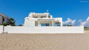 A modern beach house with a white exterior, a covered patio, and a clear view of the beach. - 1685 Villa Diamante in Campomarino (Maruggio)