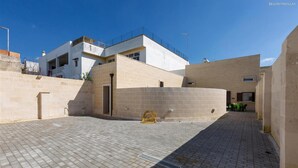 Ein Innenhof mit befestigtem Boden, ein Gebäude mit Balkon und ein kleiner Tisch mit Stühlen.