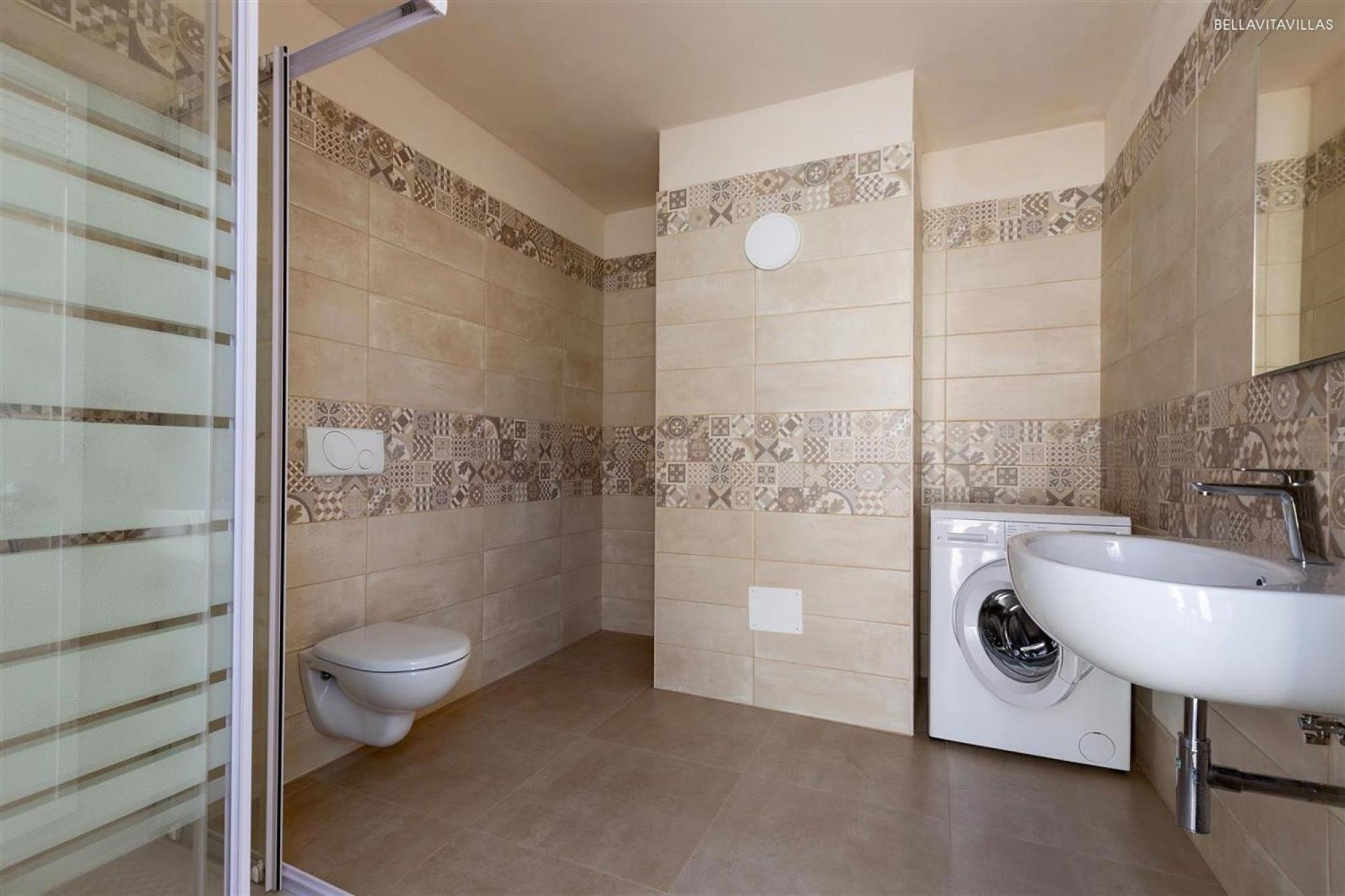 Un baño con inodoro, lavadora y lavabo.