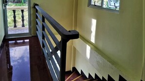 Una escalera con barandilla de madera que conduce a una habitación con ventana.