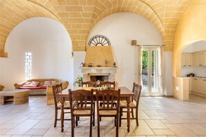 A spacious living room with a fireplace, dining table, and seating area. - 373 Villa con Piscina a Casarano Gallipoli (Casarano)