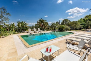 A swimming pool with lounge chairs and a table with drinks, surrounded by greenery. - 373 Villa con Piscina a Casarano Gallipoli (Casarano)