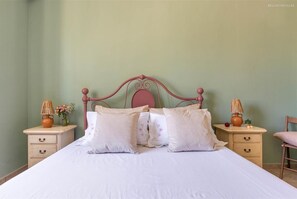 A bed with a pink metal headboard, two bedside tables with lamps, and a chair. - 373 Villa con Piscina a Casarano Gallipoli (Casarano)