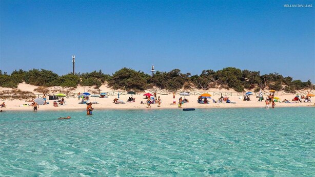 A beach with clear turquoise water, people sunbathing, and umbrellas. - 1432 Trilo Stella Di Mare 2 (Porto Cesareo)