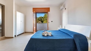 A bedroom with a bed, a wardrobe, a door leading to an outdoor area, and a ceiling fan. - 1786 B B Joy Home - Camera 2 (Maruggio)
