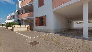 Ein mehrstöckiges Wohngebäude mit überdachtem Außenbereich und befestigtem Eingang.