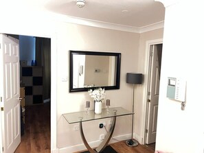 Enter a stylish space with a console table, mirror, and floor lamp, offering ample lighting and storage.