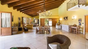 A spacious living area with a high wooden ceiling, a chandelier, and a dining area with a table and chairs. - 425 Casa in Campagna con Piscina a San Donaci (San Donaci)