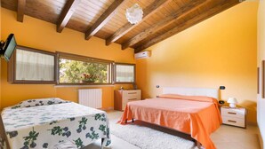 A bedroom with a wooden ceiling, two beds, a window with a view, a radiator, and a bedside table with a lamp. - 425 Casa in Campagna con Piscina a San Donaci (San Donaci)