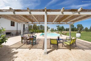 A covered outdoor area with a pool, seating, and a pergola structure. - 425 Casa in Campagna con Piscina a San Donaci (San Donaci)