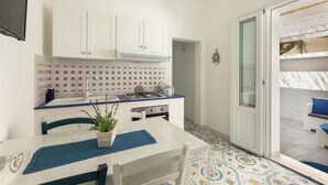 A compact kitchen with white cabinets, a blue countertop, and a patterned backsplash. - 1687 Villa Blu Cobalto - Appartamento 1 (Manduria)