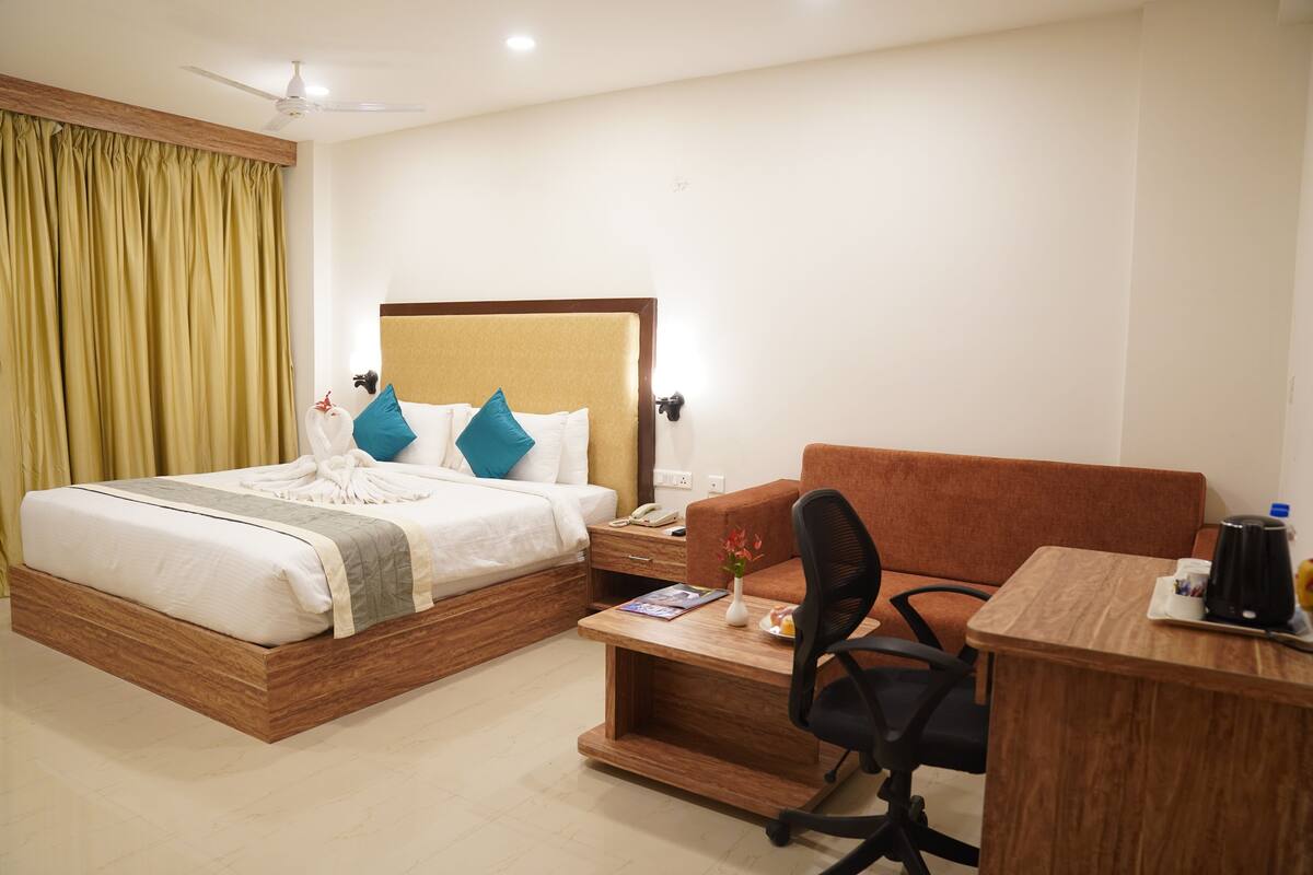 Una habitación de hotel con cama, escritorio y silla.