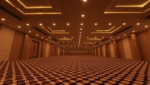 A spacious, well-lit hotel corridor with a patterned carpet and modern lighting fixtures. - Seven Hills Hotels (Puri)
