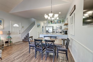 A modern kitchen with white cabinets, stainless steel appliances, and a central island.