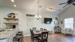 A spacious kitchen with a dining area, wooden flooring, and a ceiling fan. - New Listing: Peach Paradise (Port Aransas)