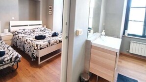 Un dormitorio moderno con dos camas, un espejo grande, un escritorio y una ventana.