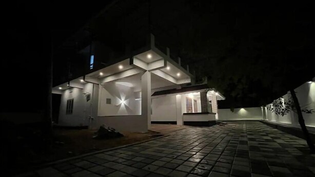 A modern house with a covered patio area, a tiled walkway, and a small garden. - Home in Varkala (Varkala)