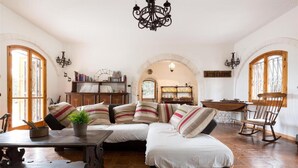 A cozy living room with a sectional sofa, wooden coffee table, and a chandelier. - 751 Trullo con Piscina e Pineta a Locorotondo (Locorotondo)