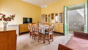 A compact living space with a dining area, kitchenette, and a bed.