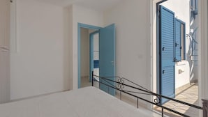 A staircase with a metal railing leading to a room with a white bed. - 1514 Villetta Michela (Nardò)