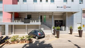 A modern hotel with a grey facade, a visible entrance, and a staircase leading to the upper floor. - 1743 Silver Hotel - Singola Business (Matino)