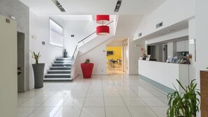 A modern hotel lobby with a staircase, a reception desk, and a dining area. - 1743 Silver Hotel - Singola Business (Matino)