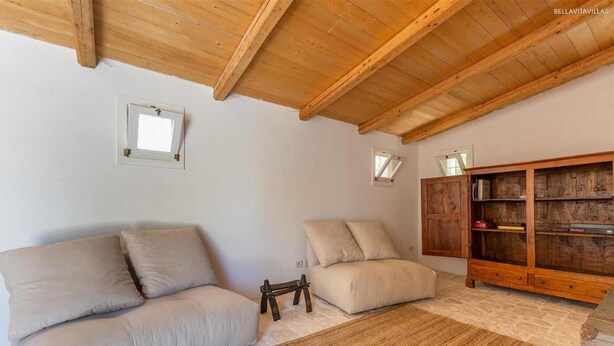 A room with a wooden ceiling, two sofas, a small table, a cabinet, and a rug. - 2410 Tenuta dei Fragni by Perle di Puglia (Ostuni)